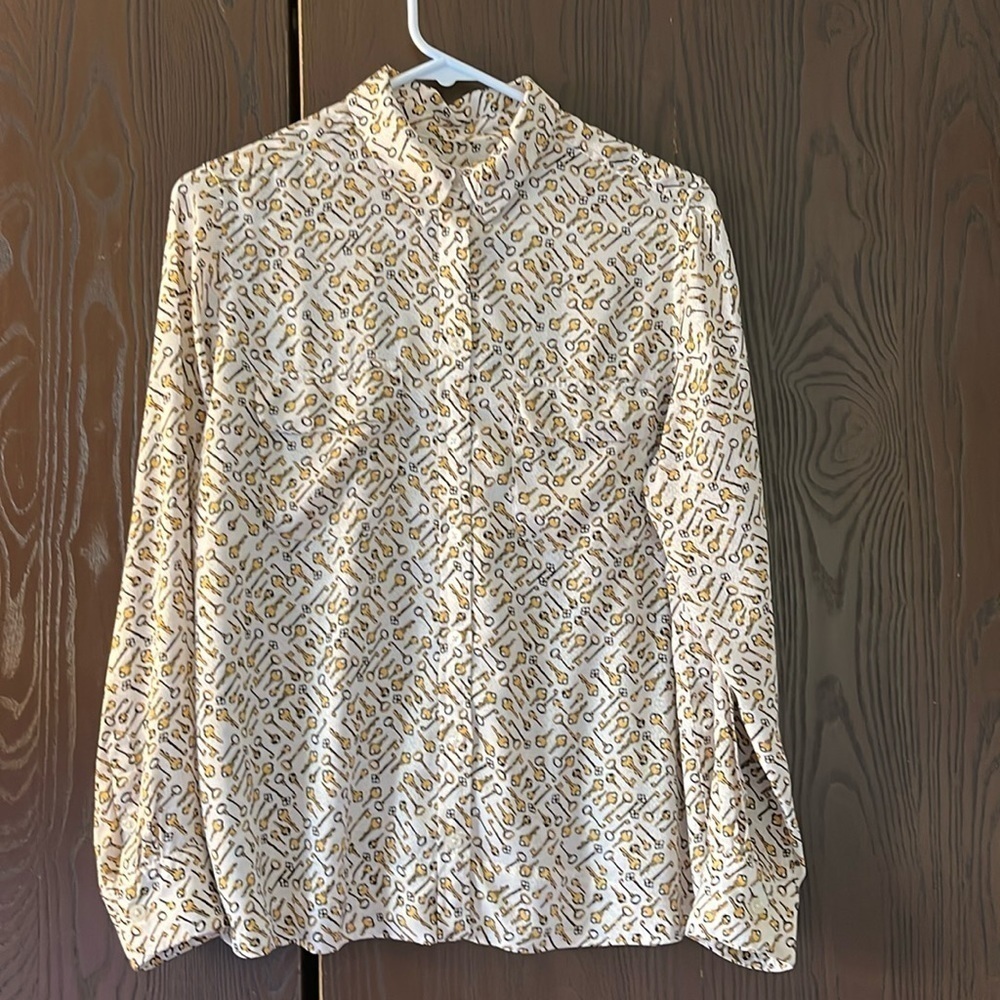 Chico’s white long sleeved silky look blouse with keys. Size Chico 1